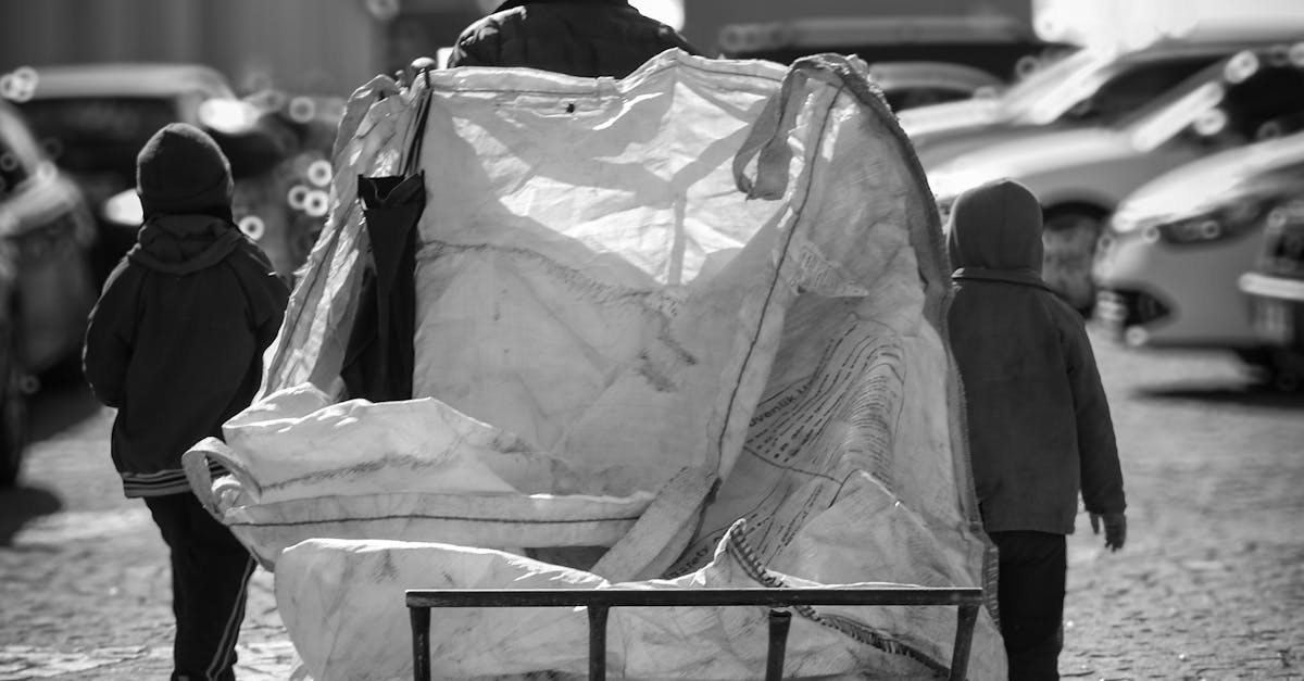 Silhouetted man pushing cart with children walking in Ankara, Türkiye. Urban life scene.